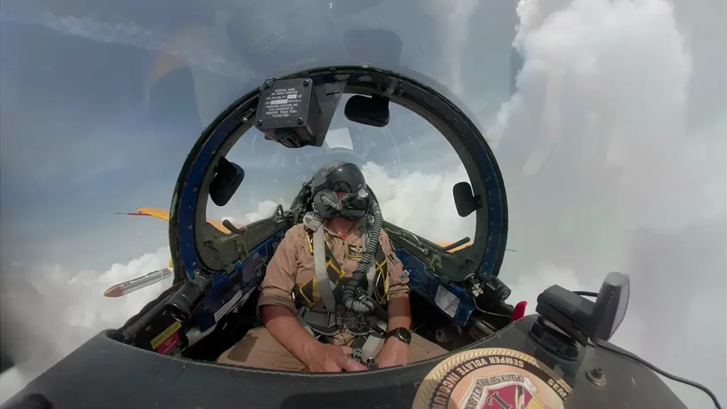 Piolet sitting in a cockpit of a plane surrounded by clouds